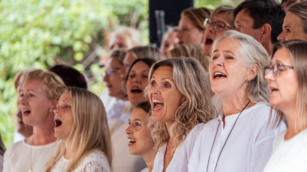 Koret Gospel Explosion leder Allsang i Kirkehagen lørdag 1. august.
